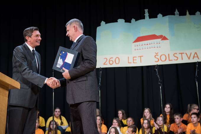 Predsednik Pahor je ravnatelju mag. Antonu Gozniku ob visokem jubileju organiziranega olstva v Voliini in prazniku Krajevne skupnosti Voliina ter v lui praznovanj 25. obletnice samostojnosti in mednarodnega priznanja podaril posebno protokolarno darilo - zastavo Republike Slovenije.